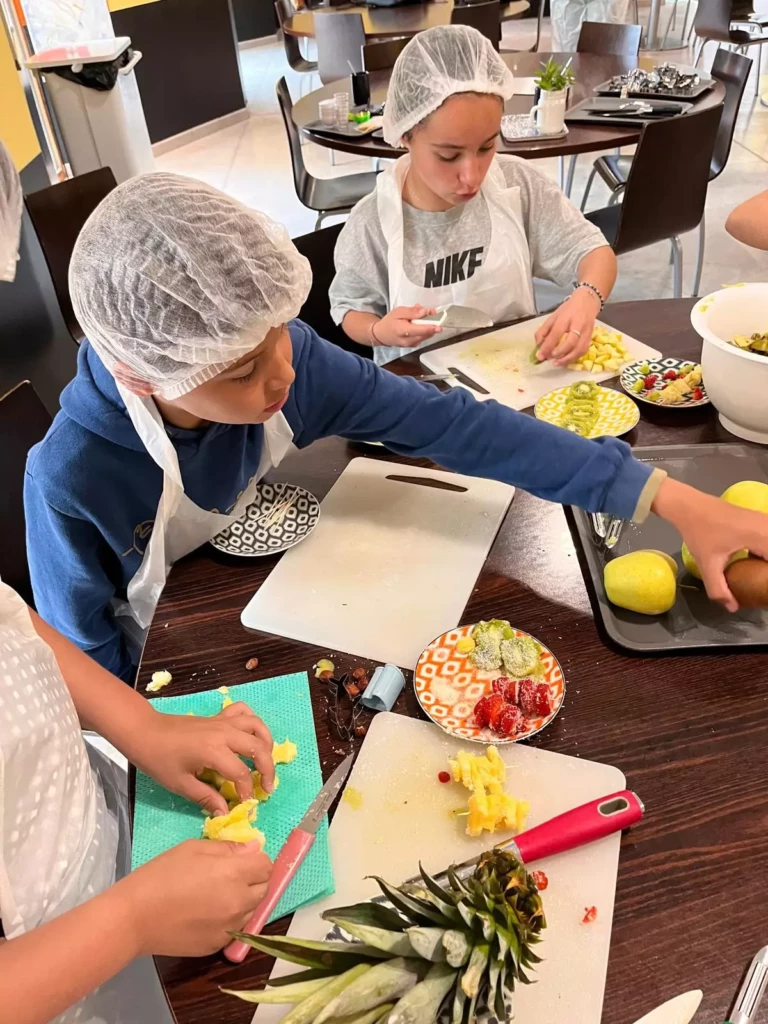 Enfants préparant des fruits lors d’un atelier cuisine éducatif sur le diabète