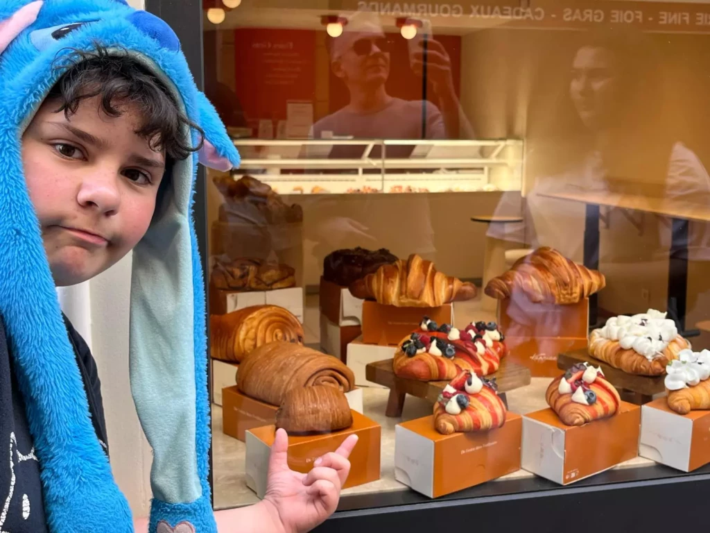 Enfant devant une vitrine de pâtisserie lors d’un apprentissage des choix alimentaires