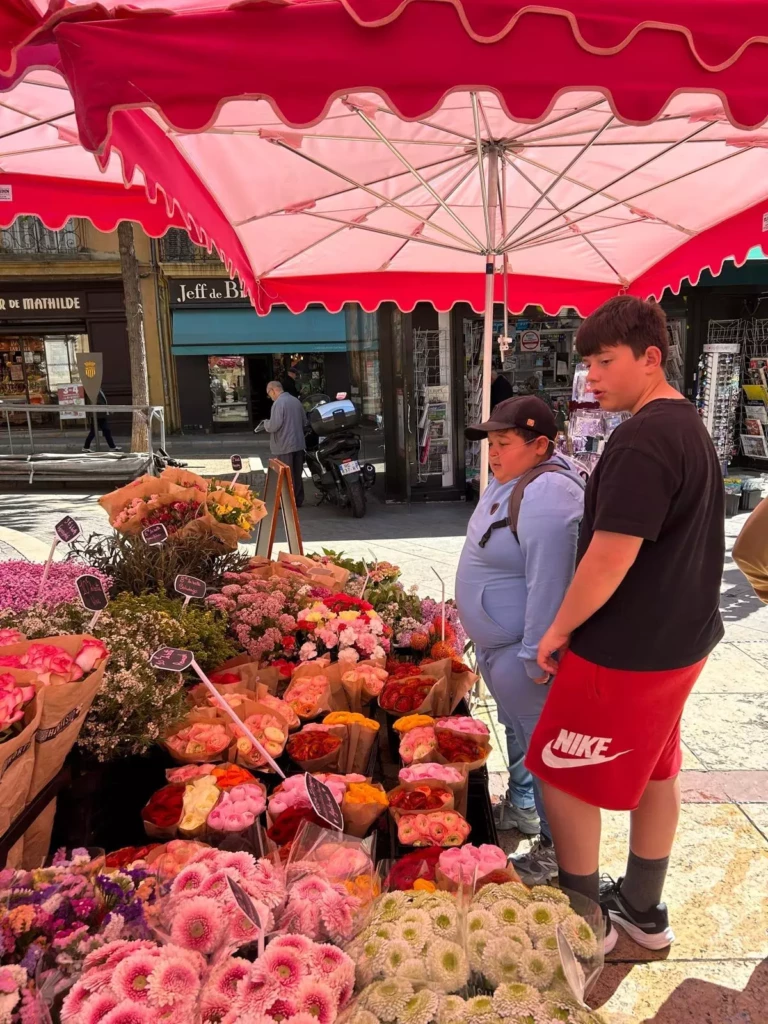 Enfants découvrant un stand de fleurs au marché lors d’un mini-séjour santé éducatif